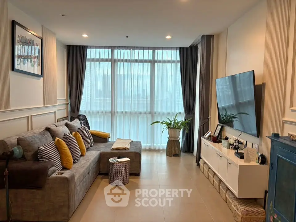 Modern living room with stylish decor, large windows, and cozy seating area.