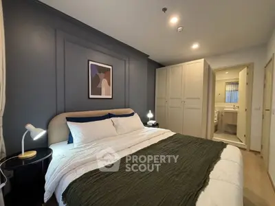 Elegant bedroom with modern decor and ensuite bathroom in stylish apartment
