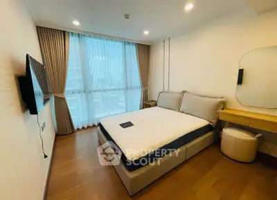 Modern bedroom with large window and stylish decor in a high-rise apartment.