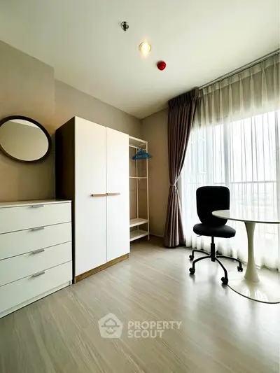 Modern study room with sleek furniture and large window for natural light.