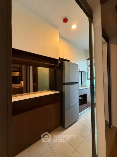 Modern kitchen with sleek cabinetry and stainless steel appliances in a stylish apartment.