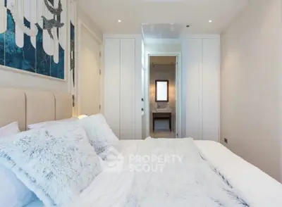 Luxurious bedroom with plush bedding and elegant decor in modern apartment.