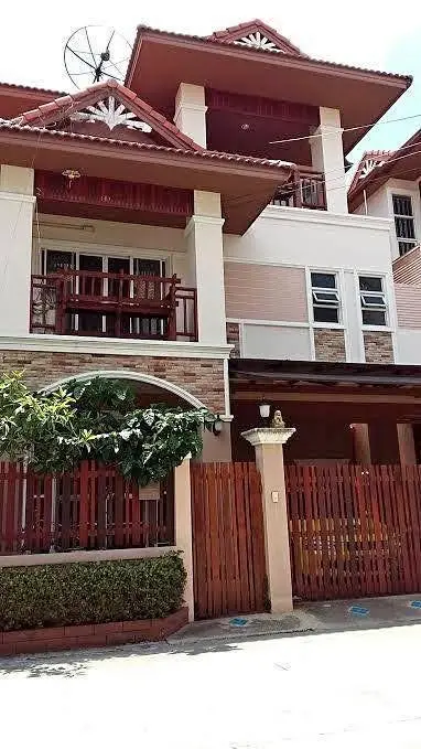 Charming multi-story house with red accents and a satellite dish, perfect for family living.