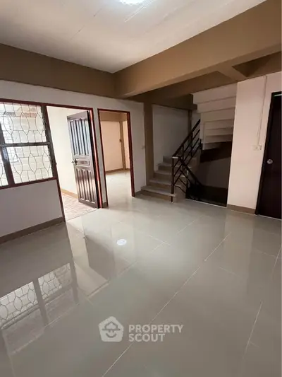 Spacious interior with modern staircase and tiled flooring, ideal for family living.