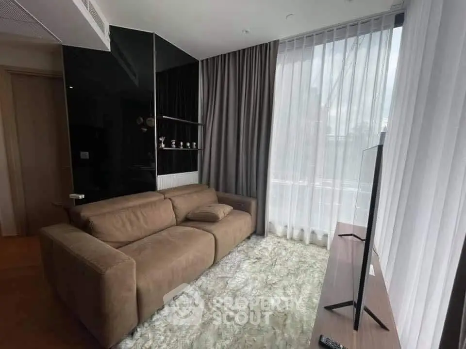 Modern living room with plush sofa and large window drapes, perfect for relaxation.