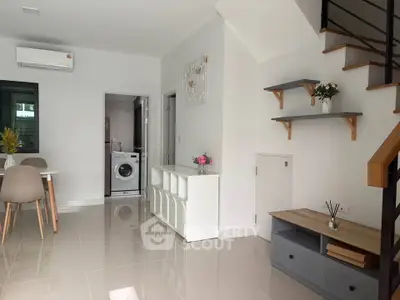 Modern living room with sleek staircase and washing machine in open layout