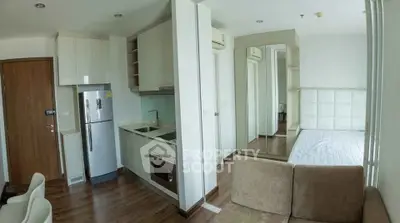 Modern studio apartment with compact kitchen and cozy living area, featuring sleek design and ample natural light.
