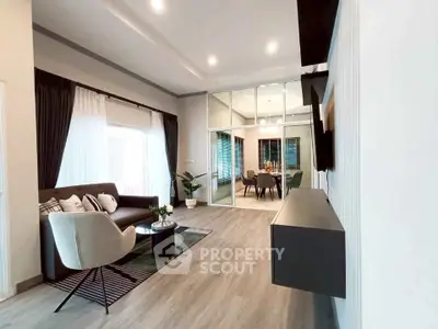 Modern living room with elegant decor and open layout, featuring stylish furniture and large windows.