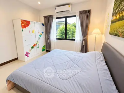 Bright and cozy bedroom with large window and colorful wardrobe