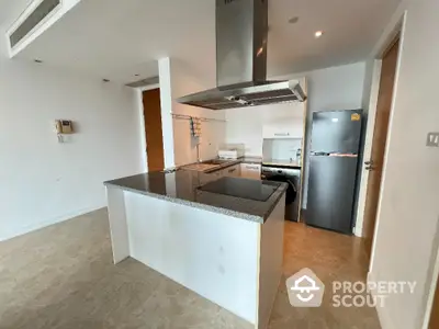 Modern kitchen with sleek appliances and granite countertops in a contemporary apartment.