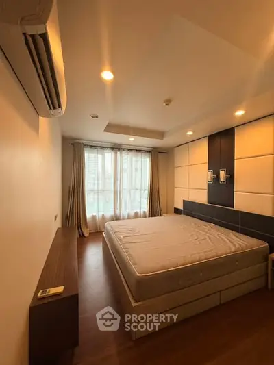 Spacious bedroom with modern design and large windows for natural light.