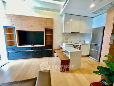 Modern open-plan living room with sleek kitchen and stylish wooden flooring.