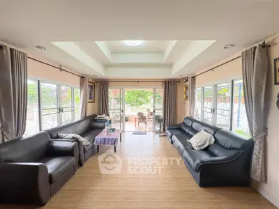 Spacious living room with large windows and elegant black sofas