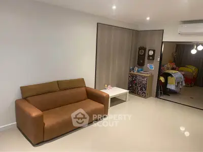 Spacious living room with modern decor and cozy brown sofa, perfect for relaxation.