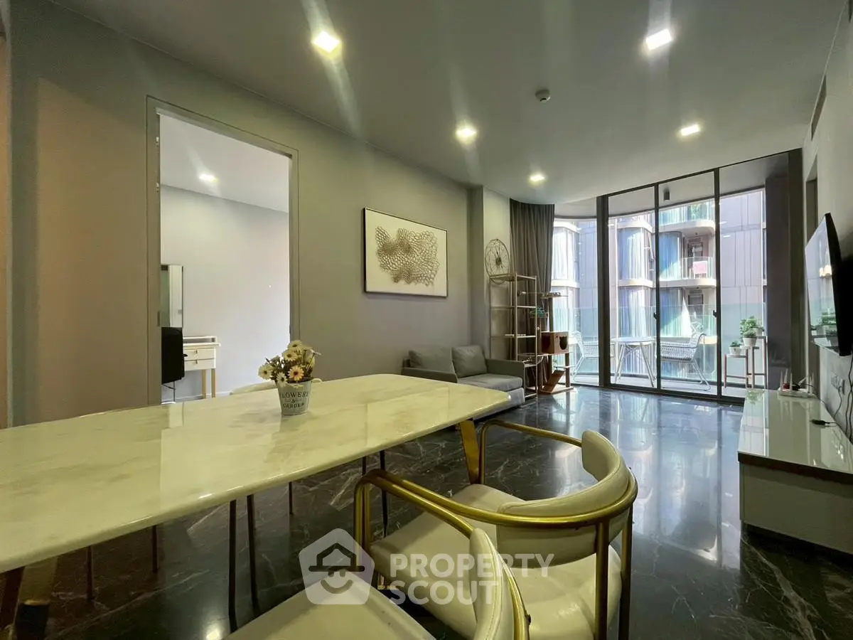 Modern living room with marble table and large windows offering a stunning view.