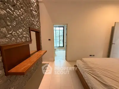 Modern bedroom with stone accent wall and minimalist design