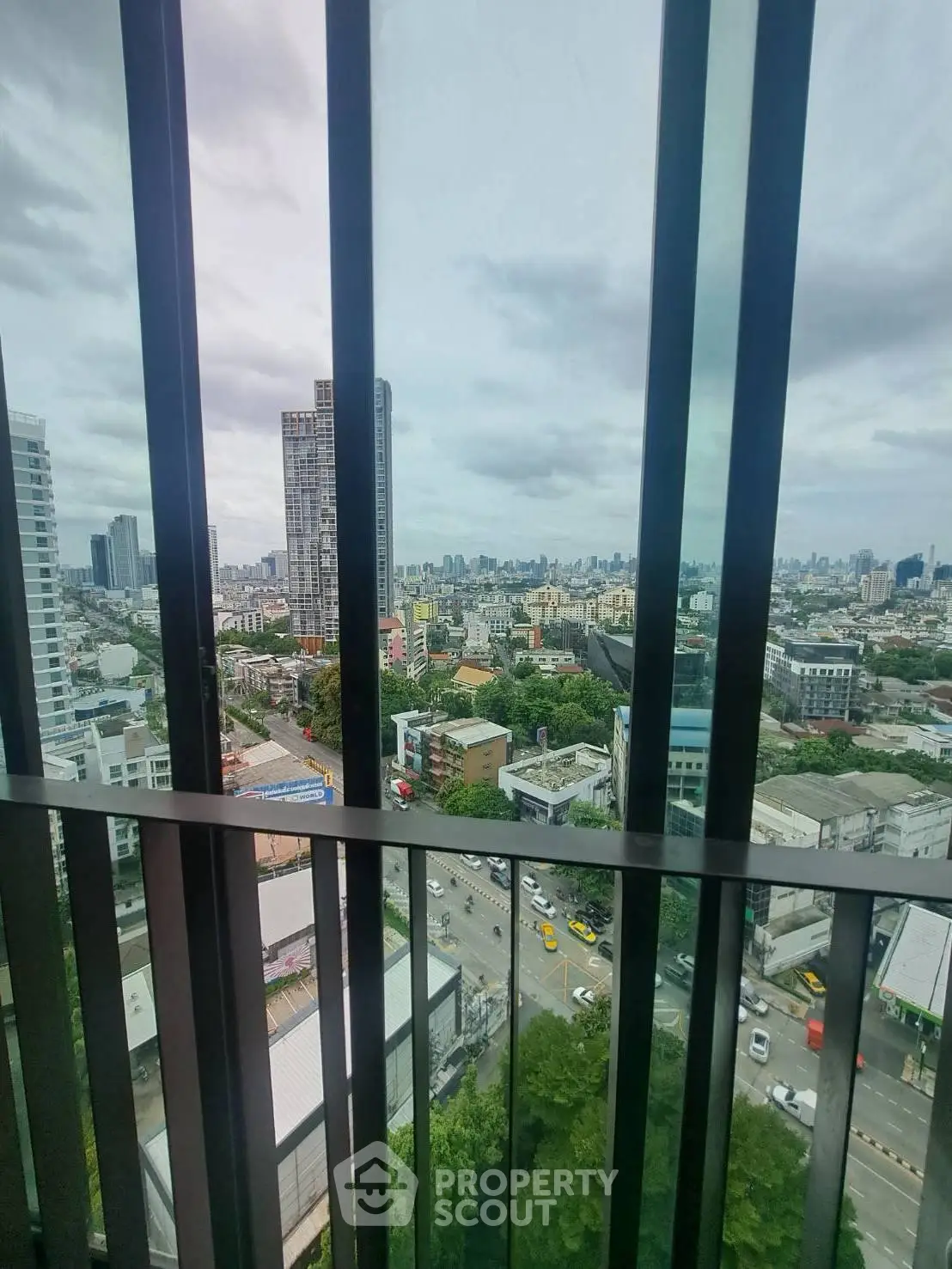 Stunning cityscape view from high-rise balcony with modern railing design.
