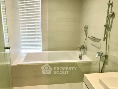 Modern bathroom with sleek bathtub and elegant fixtures, perfect for relaxation and comfort.