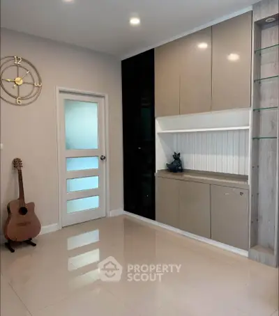 Modern living room with sleek cabinetry and decorative guitar, ideal for stylish home living.
