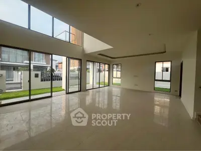 Spacious modern living room with large windows and elegant flooring in a luxury home.