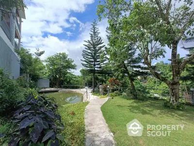 Serene garden with lush greenery and pond in a residential complex