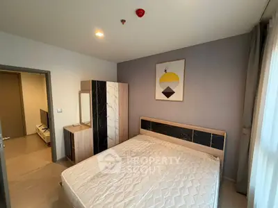 Modern bedroom with stylish decor and natural light, featuring a comfortable bed and sleek wardrobe.