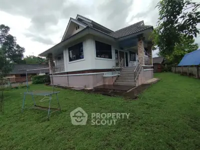 Charming single-story house with lush green lawn and elevated entrance, perfect for serene living.