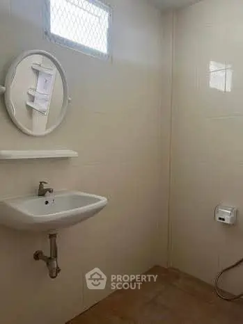Minimalist bathroom with wall-mounted sink and round mirror