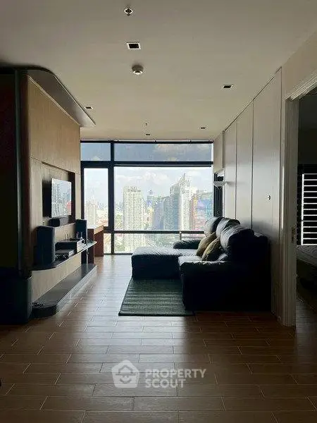 Modern living room with city skyline view, featuring sleek furniture and large windows.