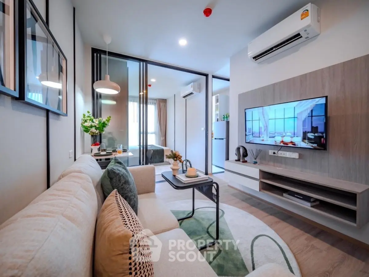 Modern living room with stylish decor and wall-mounted TV in a cozy apartment.