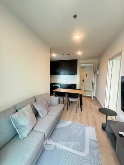 Modern living room with cozy sofa and stylish kitchen in open layout apartment
