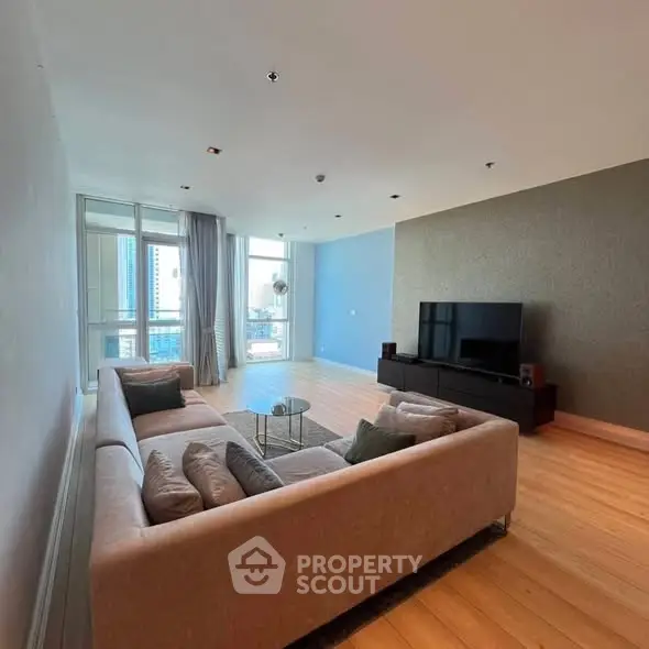 Spacious modern living room with large sofa and city view, perfect for relaxation.
