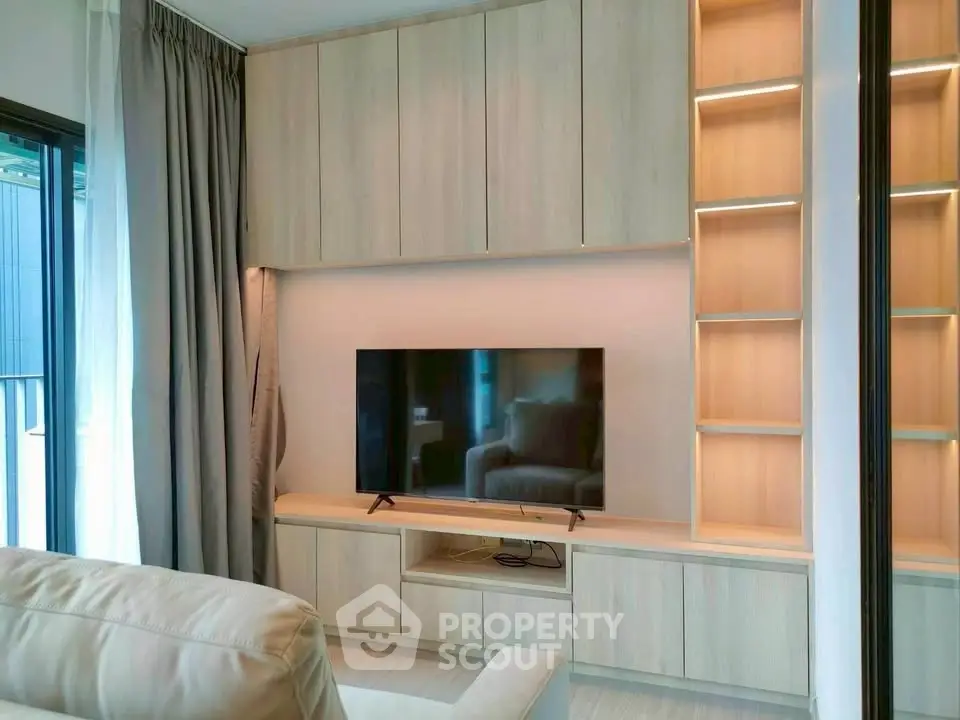 Modern living room with sleek built-in wooden cabinets and a flat-screen TV, perfect for stylish urban living.