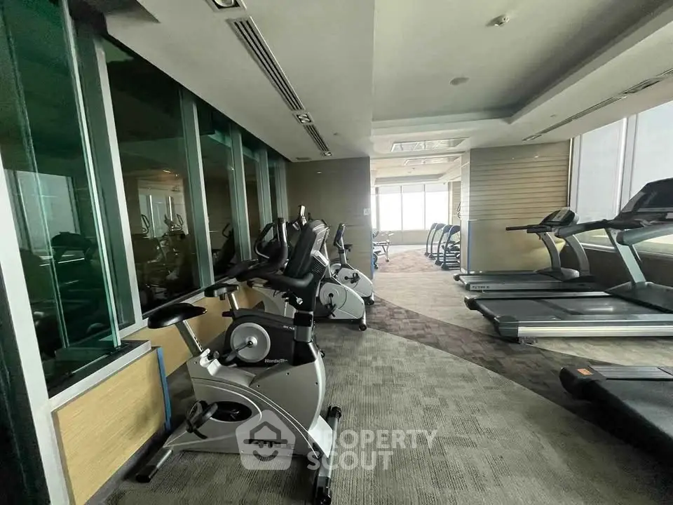 Modern gym with exercise bikes and treadmills in a high-rise building