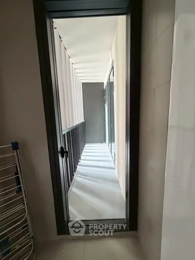 Modern apartment balcony with sleek design and glass door access