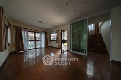 Spacious living room with wooden flooring and large windows in a modern home
