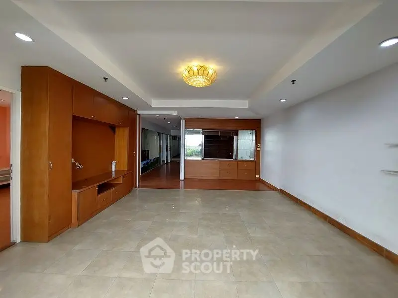 Spacious living room with elegant wooden cabinetry and modern lighting