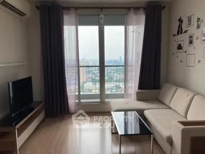 Modern living room with city view, featuring a cozy sofa and sleek TV setup.
