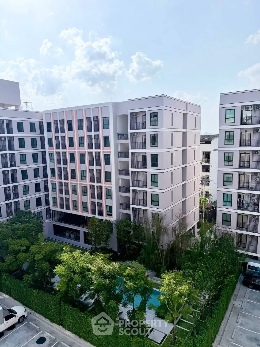 Modern apartment building with lush greenery and pool view