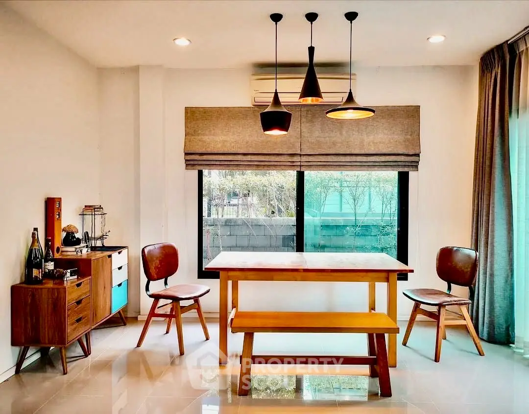 Chic dining area with modern wooden table, stylish chairs, and ambient lighting.