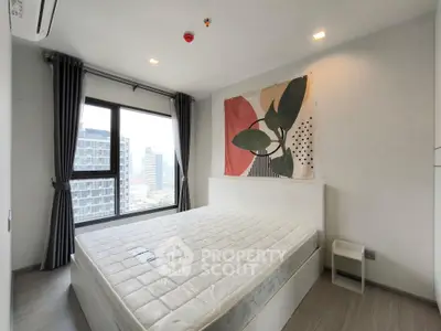 Modern bedroom with large window and city view, featuring stylish wall art and minimalist decor.