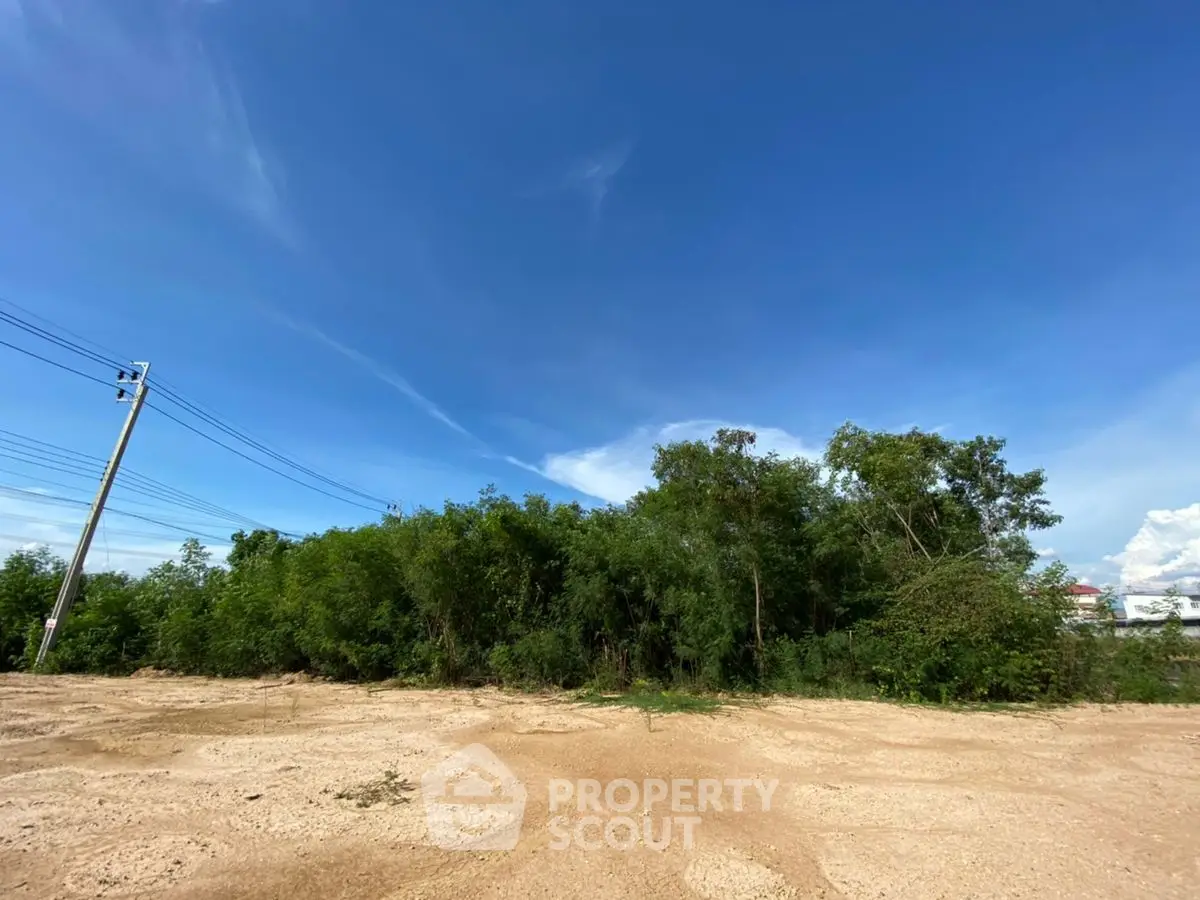 Expansive vacant land with clear blue sky, ideal for development opportunities.