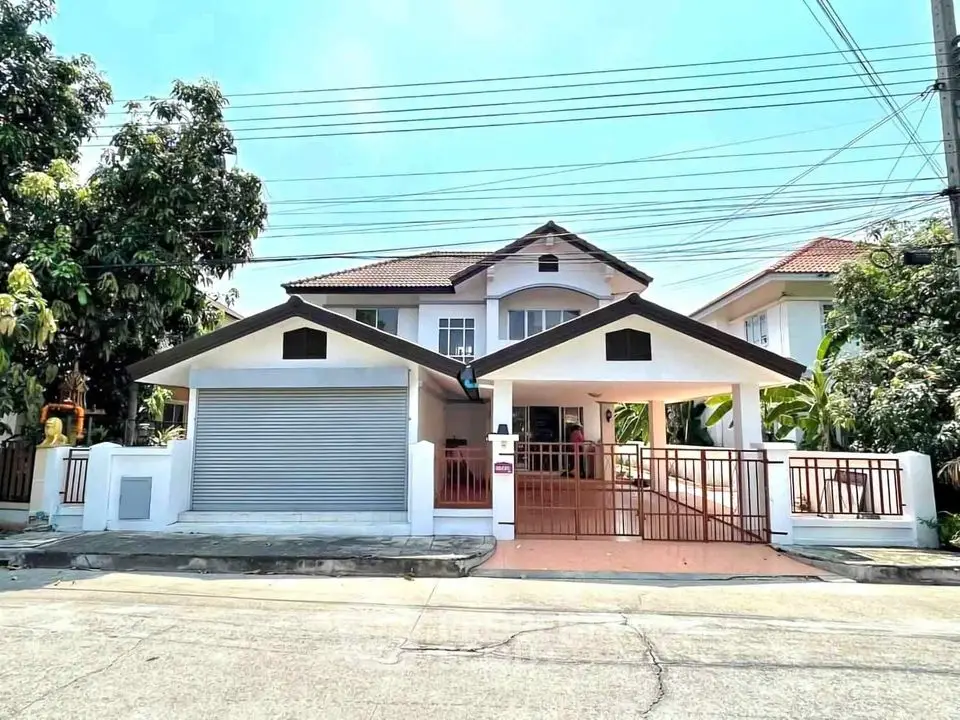 Charming two-story house with spacious garage and lush greenery in a serene neighborhood.