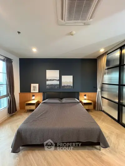 Modern bedroom with stylish decor and large windows in a contemporary apartment.