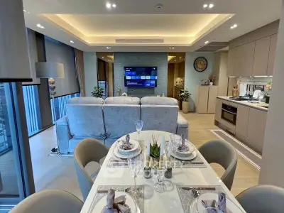 Luxurious open-plan living room and kitchen with elegant dining setup and modern decor.