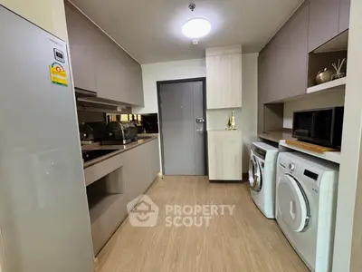 Modern kitchen with sleek cabinetry, appliances, and wood flooring in a stylish apartment.