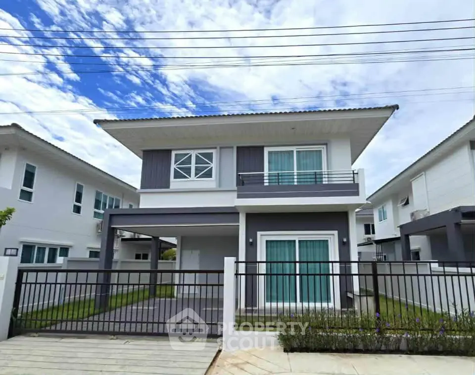 Modern two-story house with sleek design and spacious driveway in a suburban neighborhood.
