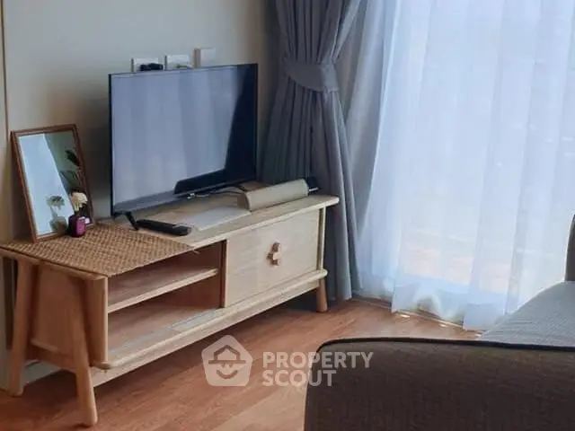 Cozy living room with modern TV setup and elegant curtains
