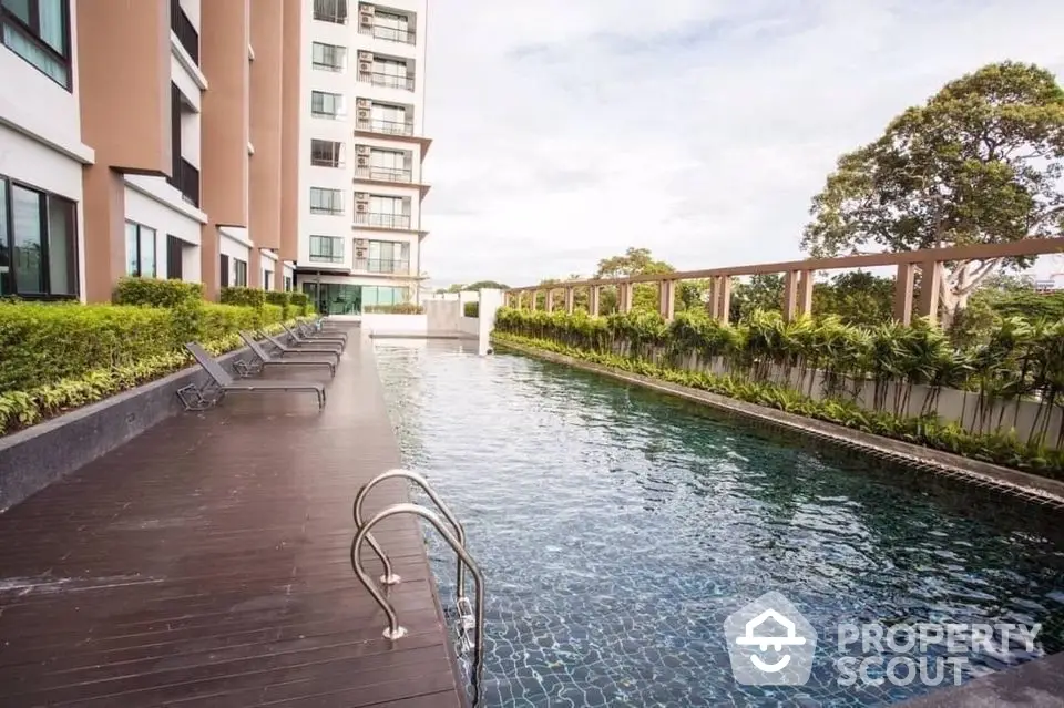 Luxurious condominium with serene poolside and lush greenery, perfect for relaxation and leisure.