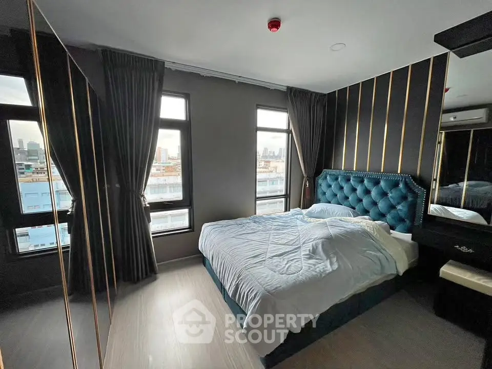 Luxurious bedroom with city view, elegant decor, and plush bedding in modern apartment.